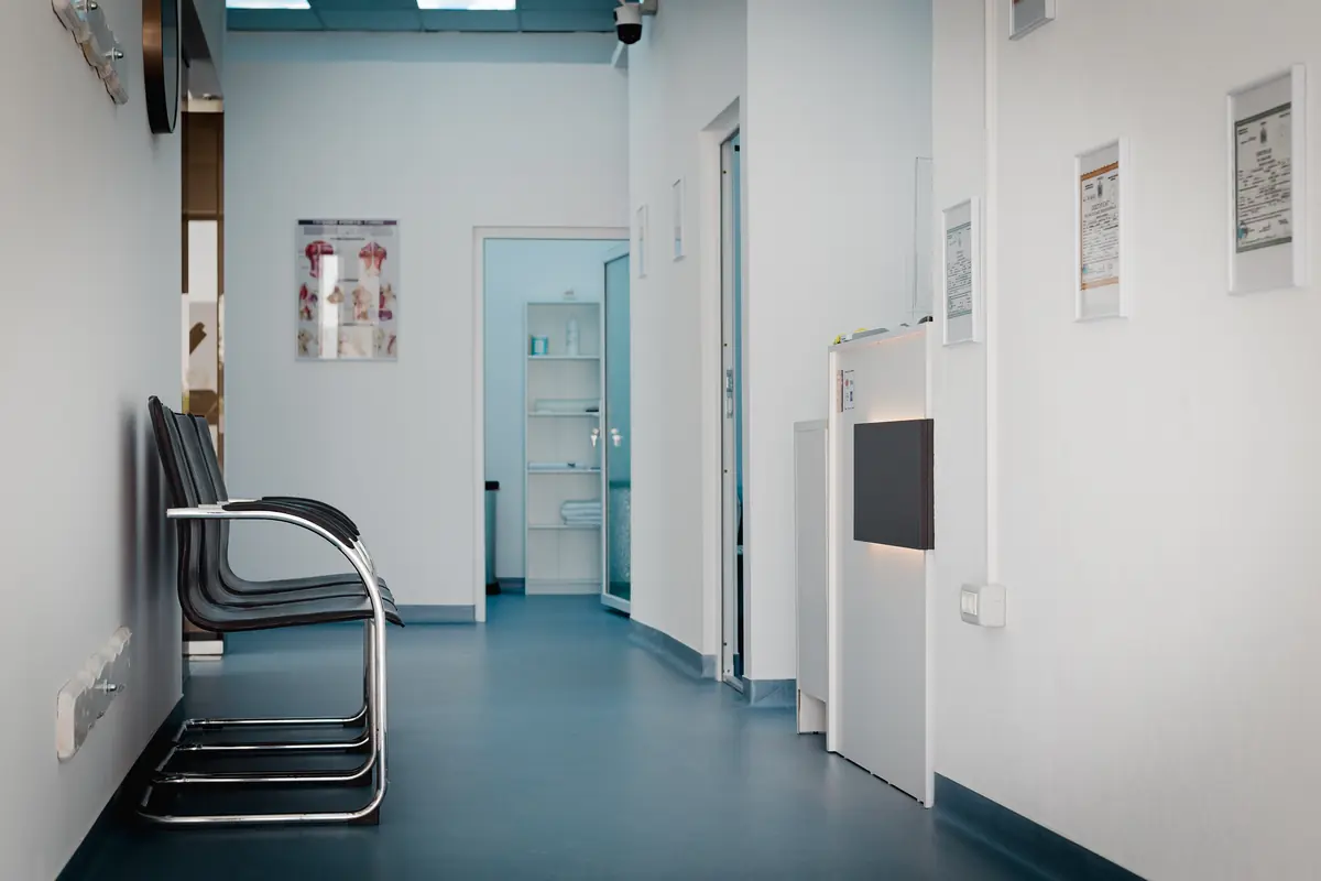 Recepția Motion Clinic — personal la birou cu monitor, logo Motion Clinic pe front desk, flori și materiale pentru pacienți; spațiu modern Snagov Plaza, Ilfov.